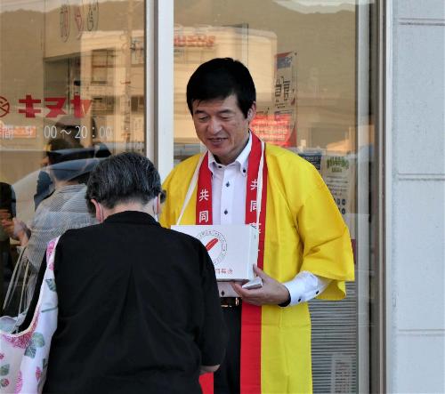 キヌヤ益田ショッピングセンター店舗入り口で買い物客らに共同募金のお願いの声かけをしている市長の写真