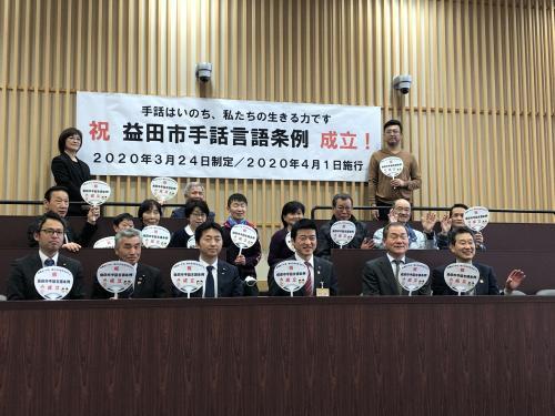 手話言語条例成立を祝う様子の集合写真