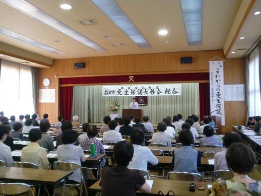 益田市更生保護女性会総会にて壇上で挨拶をする市長と耳を傾ける参加者たちの写真