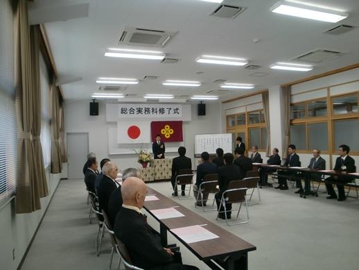 西部高等技術校総合実務科第8期修了式で壇上からの市長の挨拶に耳を傾ける生徒並びに関係者の様子の写真