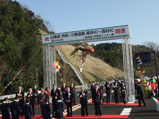 山陰道浜田三隅道路開通式にてくす玉が割れ、セレモニーが執り行われている様子の写真