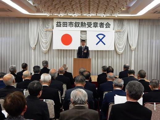 益田市叙勲受章者会にて挨拶を述べる市長と耳を傾ける参列者らの写真