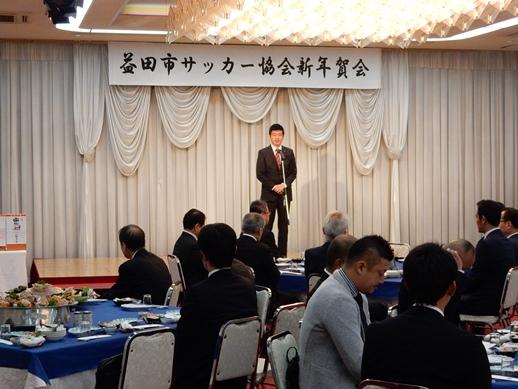 益田市サッカー協会新年賀会にて挨拶を述べる市長と耳を傾ける参列者らの写真