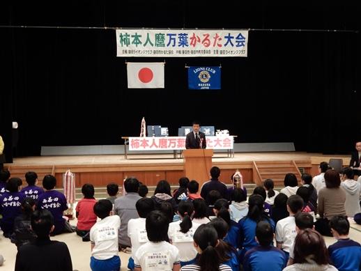 柿本人麿呂万葉かるた大会にて挨拶をする市長と耳を傾ける参加者らの写真