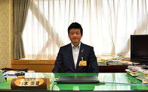 益田市長 山本浩章氏が自身の机に座っている写真