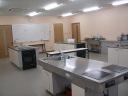 銀色の大きな調理台がある調理実習室の写真