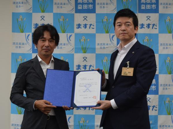 大見工業株式会社代表取締役社長と益田市長が一緒に書状をもっている様子の写真