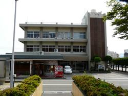 広い駐車場のある3階建ての益田商工会議所の外観の写真