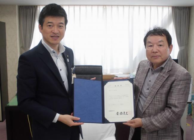 阪神食品株式会社社長と益田市長が一緒に書状を持っている様子の写真