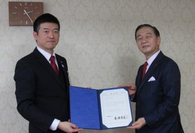 サン電子工業株式会社代表取締役社長佐藤氏と市長が一緒に書状を持っている様子の写真