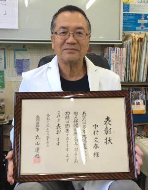 表彰状を手に持つ中村文春医師の写真