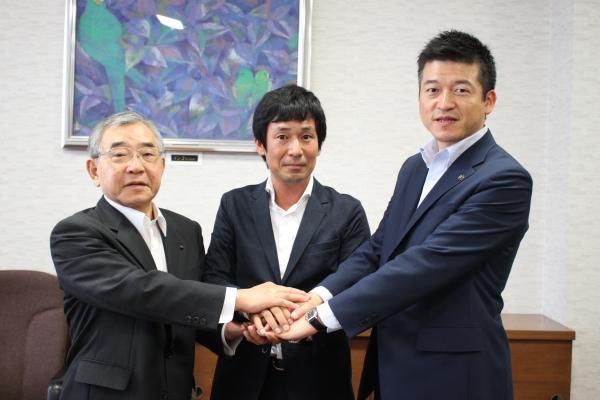 溝口知事、大見代表取締役、山本市長ら3人で手を組む様子の写真
