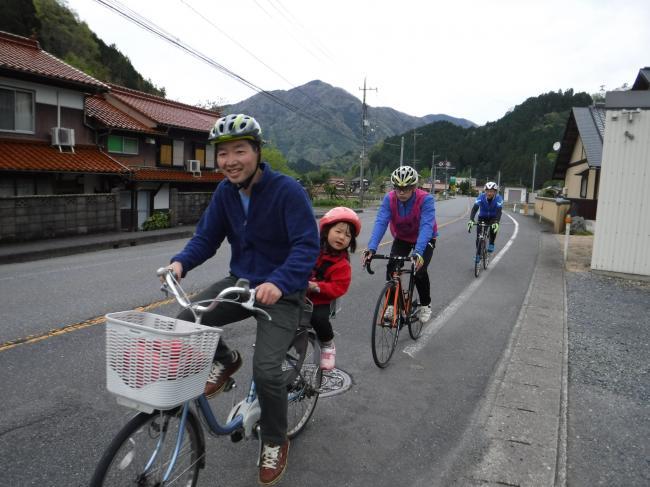 子供を後ろに乗せて自転車で走る参加者