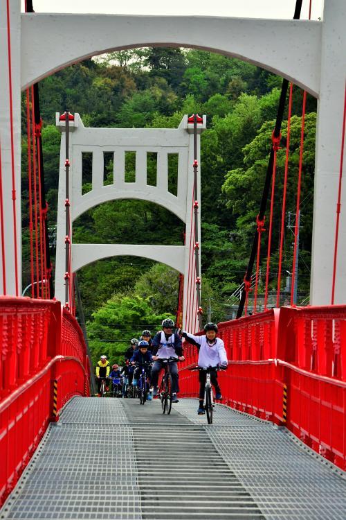 自転車で吊橋を渡る参加者たち