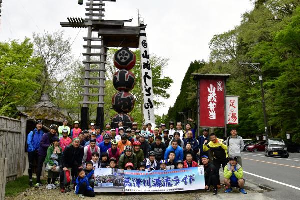 櫓の前で横断幕で記念撮影する参加者たち