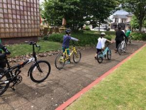 自転車を押しながら歩く子ども達の写真