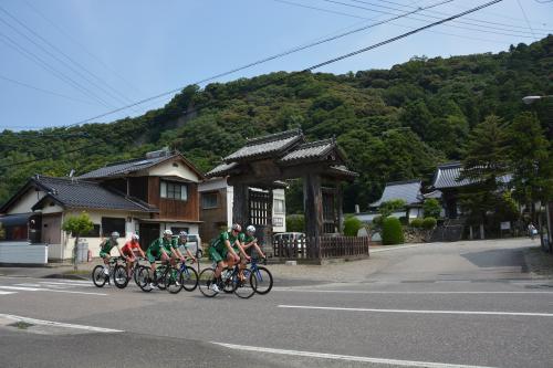 古い街並みを背に道路を走る選手たちの練習風景の写真