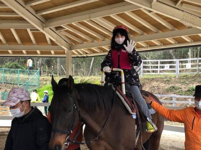 馬に乗って手を振る女の子の写真