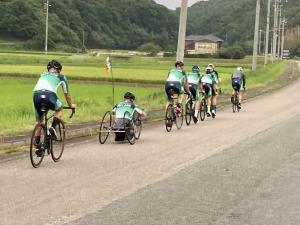 田園の広がる道を自転車で走る選手たちの様子