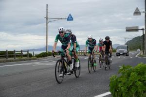 道路を並んで自転車で走る選手たちの様子