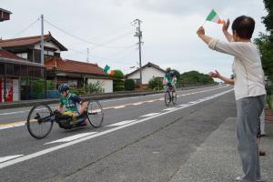 道路を走る選手に沿道から声援を送る女性