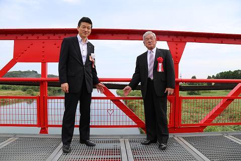 転落防止柵にあるハートマークを紹介する市長と飯田自治会長の写真