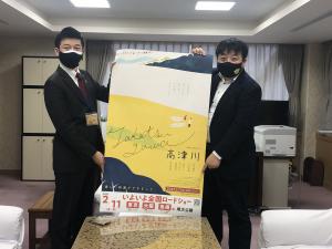 山本市長と錦織監督が映画高津川のマスクを着けポスターをもっている写真