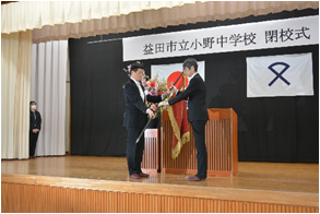小野中の校旗を返還する小野中学校長とそれを受け取る山本市長