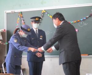 益田警察署から教育長へ塗り絵を渡される様子の写真