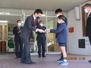 小学生に木製クラスプレートを贈呈する市長の様子の写真