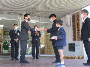中学生に木製クラスプレートを贈呈する市長の様子の写真