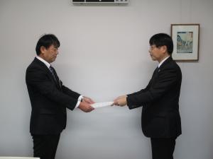 柳井教育長に答申書を提出する作野会長の写真