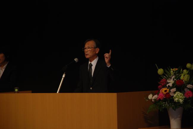 岸田裕之先生が壇上で講演する様子の写真