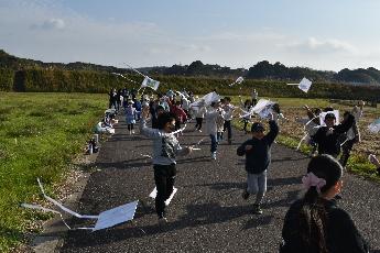 子どもたちが一斉に凧揚げしている様子