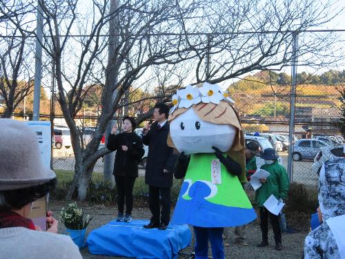 鎌手公民館に集まったウォーク参加者らの前で挨拶をしている市長の写真