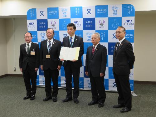 市役所大会議室でEV充電スタンド除幕式参加者と市長の集合写真