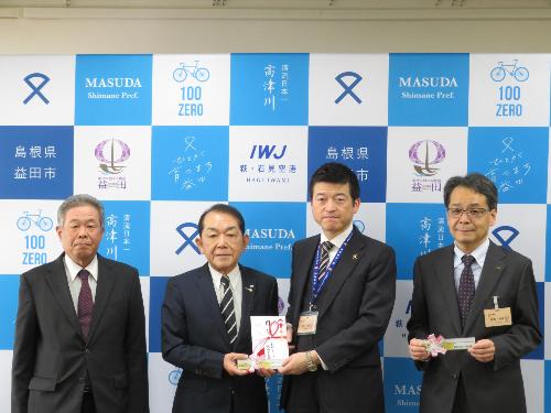 市役所大会議室で大畑グループ交通安全協議会長より交通安全標識定規の目録を手渡される市長の写真