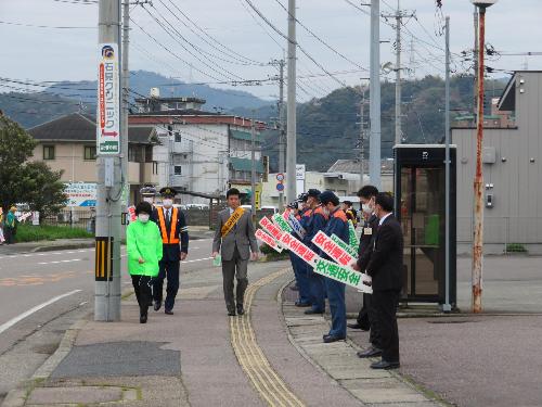 消防本部前道路歩道を益田警察署員らと交通安全を呼び掛けながら歩く市長の写真