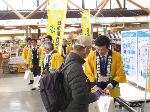 萩・石見空港搭乗口で羽田便搭乗者に美都産のゆずを手渡している市長の写真