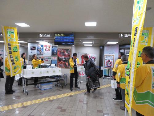 萩・石見空港降り口で羽田便から降りた乗客らに美都産のゆずを手渡している市長の写真
