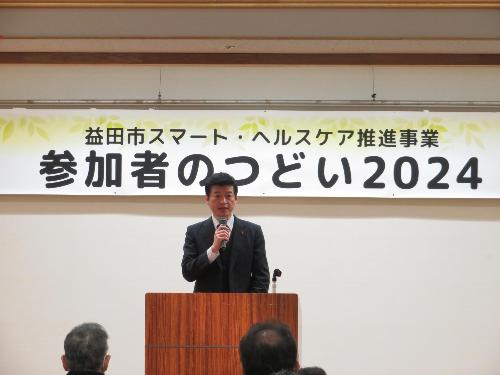 保健センター大ホールで事業者らの前でマイクを使い挨拶をしている市長の写真