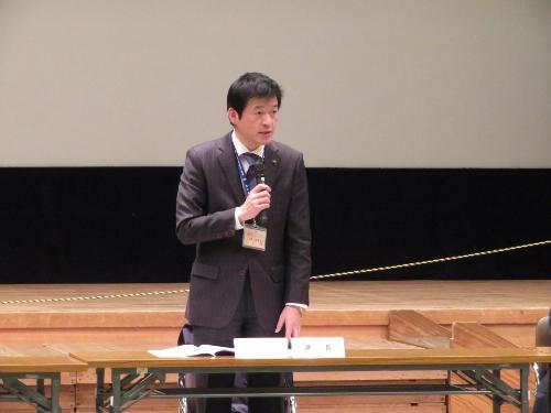 市民学習センター多目的ホールで総会参加者らにマイクを使って挨拶をしている市長の写真
