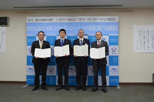 署名した協定締結書を手にする市長の写真