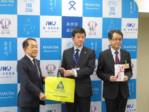 市役所第一会議室で益田市安全運転管理者協会長より反射材付き手提げ袋を手渡される市長の写真