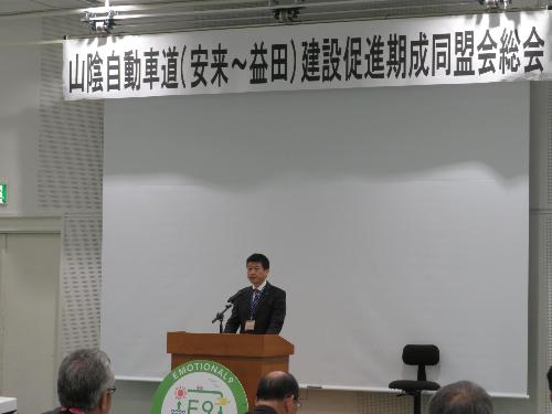 グラントワスタジオ1で総会出席者らの前で挨拶をしている市長の写真