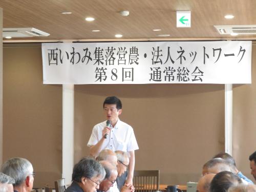 西いわみ集落営農・法人ネットワーク関係者らの前でマイクを持ち挨拶をしている市長の写真