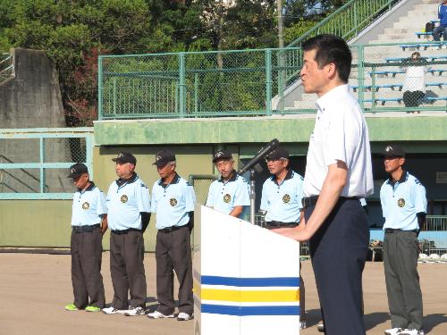益田市民球場グラウンドで演台の上に立ち大会出場選手らに激励の言葉を送る市長の写真