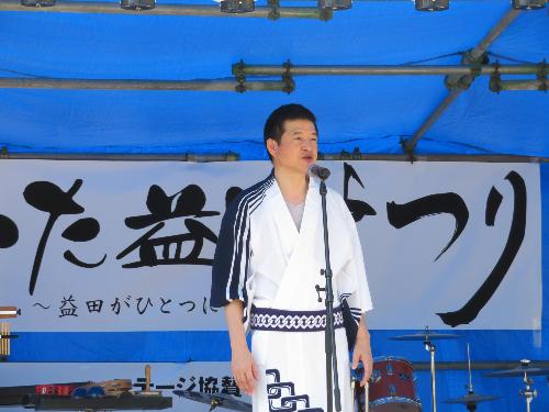 ゆかたを着て祭り会場の壇上から参加者らに挨拶をしている市長の写真