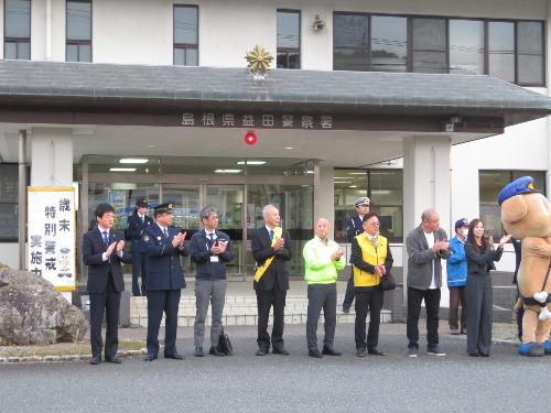 益田警察署入口前で警戒に出動するパトカーを送り出す市長の写真