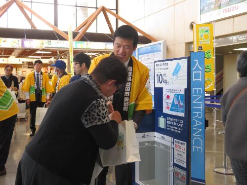 萩・石見空港ロビーで搭乗客らにゆずPR商品を手渡している市長の写真